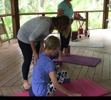 Andrea helping a yoga student in Happehatchee